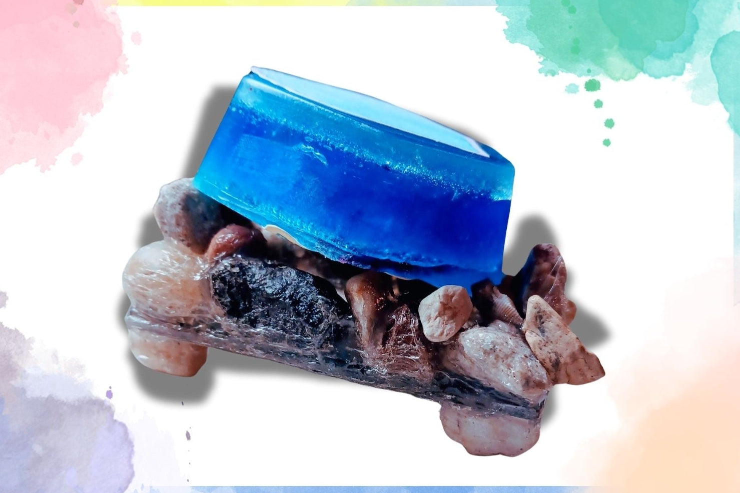 A blue rectangular hand soap placed on a dish made of stones.